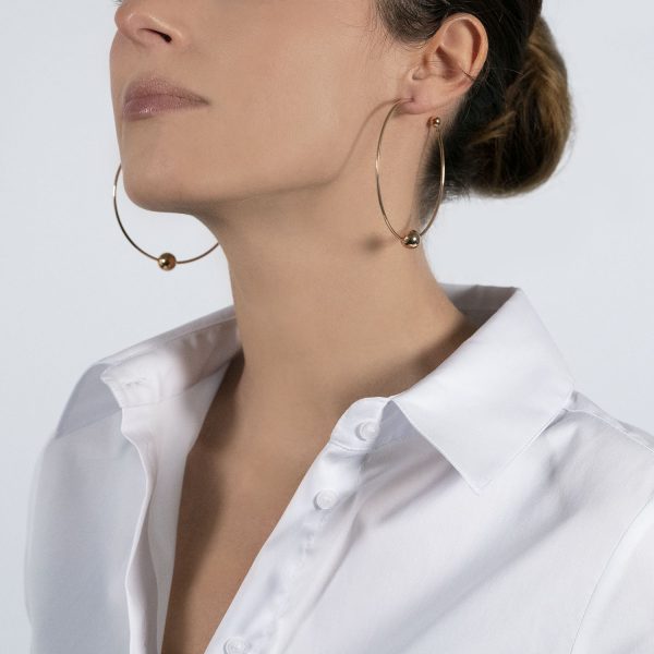 The model wears the perlage earrings in rose gold