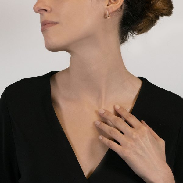 The model wears Aurum earrings with diamonds