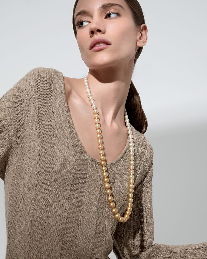 The model wears a long strand with South Sea pearls