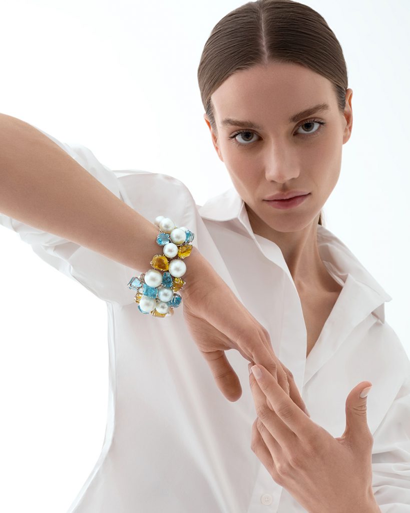 The model wears the unique bracelet with South Sea pearls and natural stones